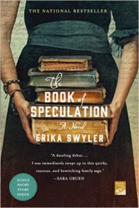 A woman wearing a blue dress holds a stack of old books. Title and author are lettered in white.