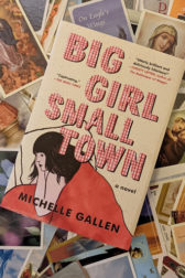 book cover with girl under red duvet, lying on a pile of catholic funeral prayer cards