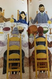 Illustration of oldfashioned family sitting around a large table, heads bowed in prayer