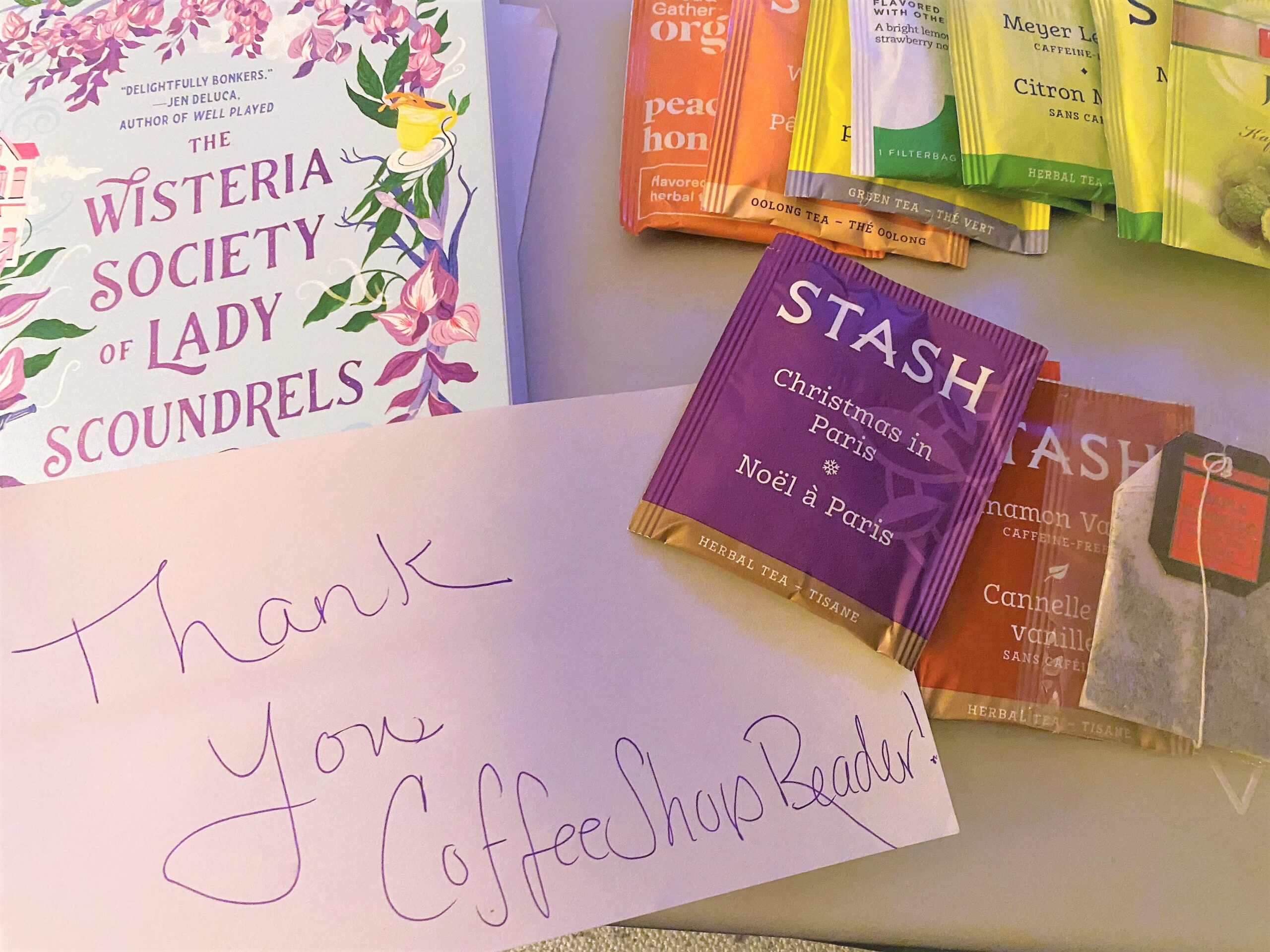 Copy of Wisteria Society ofr lady Scandals, a note that reads thank you coffee shop reader, and some packets of tea, in various flavors. 