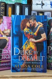 Three books standing next to each other on a bookshelf. "A Princess in Theory" "A Duke by Default" "A Prince on Paper" all written by Alyssa Cole.