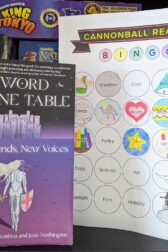 The book,"Sword Stone Table: Old Legends, New Voices" edited by Swampna Krishna and Jenn Northington next to a book bingo card.