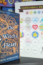 The book, "The Witch's Heart" by Genevieve Gornichec next to a book bingo card.