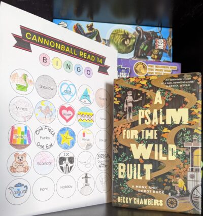 The book, "A Psalm for the Wild-Built" by Becky Chambers standing next to a mostly filled out book bingo card.