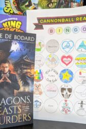 The book, "Of Dragons, Feasts, and Murder" by Aliette de Bodard standing next to an almost complete book bingo card.