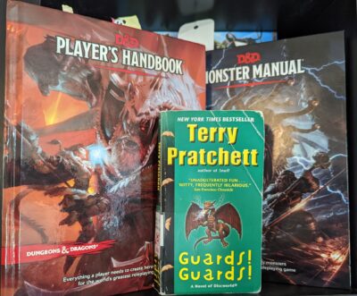 The book, "Guards! Guards!" by Terry Pratchett standing in front of the Dungeons and Dragons Player's Handbook and Monster Manual.