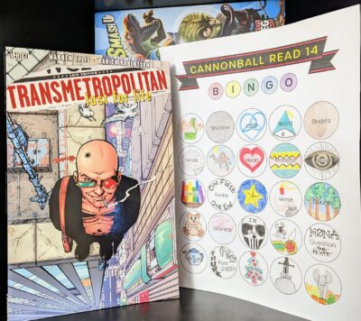The graphic novel, "Transmetropolitan: Lust for Life" by Warren Ellis and others standing next to a completely filled out bingo card.