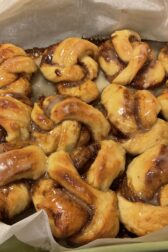 Glazed cinnamon orange knots on parchment paper. 