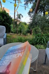 the book of The Miseducation of Cameron Post being read at an outdoor cafe on a clear summer evening