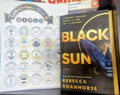 The book "Black Sun" by Rebecca Roanhorse standing next to a book bingo card with one bingo completed.