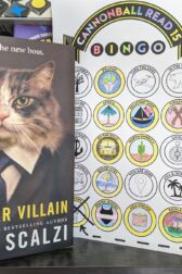 The book, "Starter Villain" by John Scalzi standing next to a book bingo card with three completed bingos.