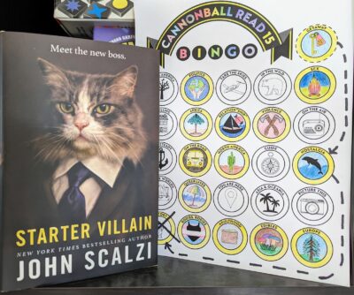 The book, "Starter Villain" by John Scalzi standing next to a book bingo card with three completed bingos.