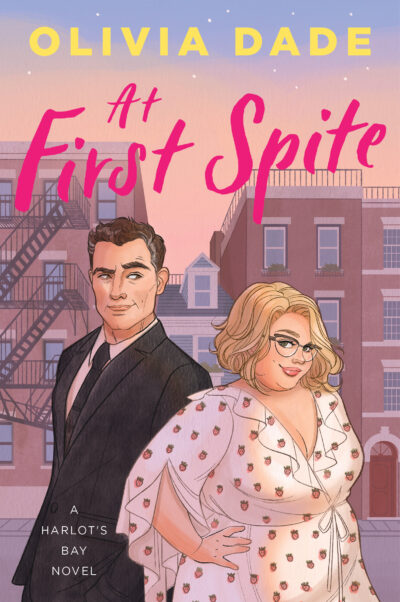 The cover of Olivia Dade's At first Spite. A tall white man in a suit with a touch of grey at his temples stands slightly behind a shorter, fat white woman wearing a strawberry print wrap dress. The couple stand in front of a row of buildings with a very narrow Spite House squished between two taller buildings. 