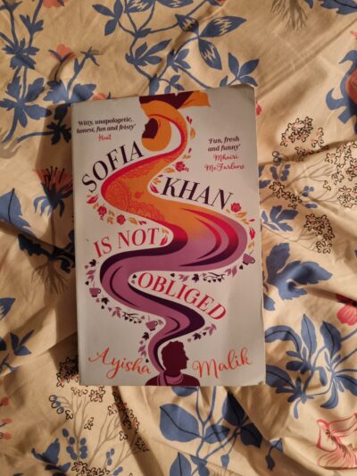 Cover of Sofia Khan is Not Obliged. It's a silhouette of a woman with a floating headscarf. 