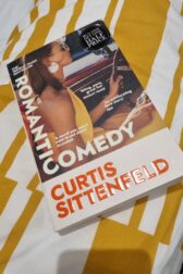 Cover of Romantic Comedy--a woman in a yellow halter top and sunglasses driving a car