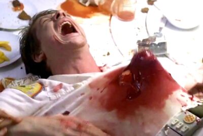 Scene from the movie Alien: an alien popping through a man's stomach