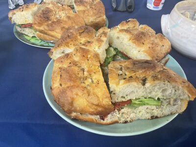 A plate of focaccia stuffed with lemon artichoke chicken salad, roasted red pepper, and romaine.