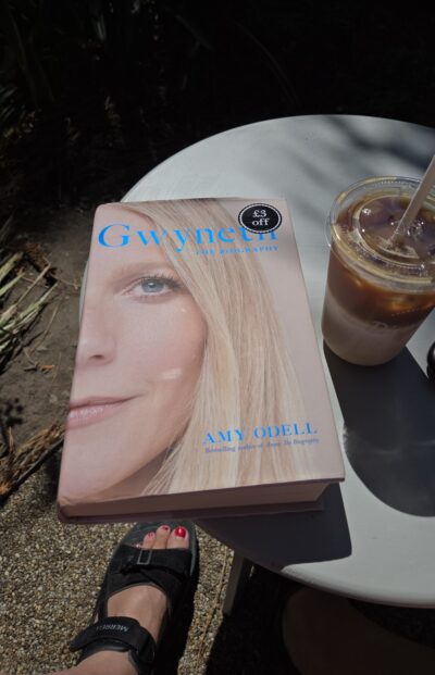 hardback copy of Gwyneth on a table with an iced latte